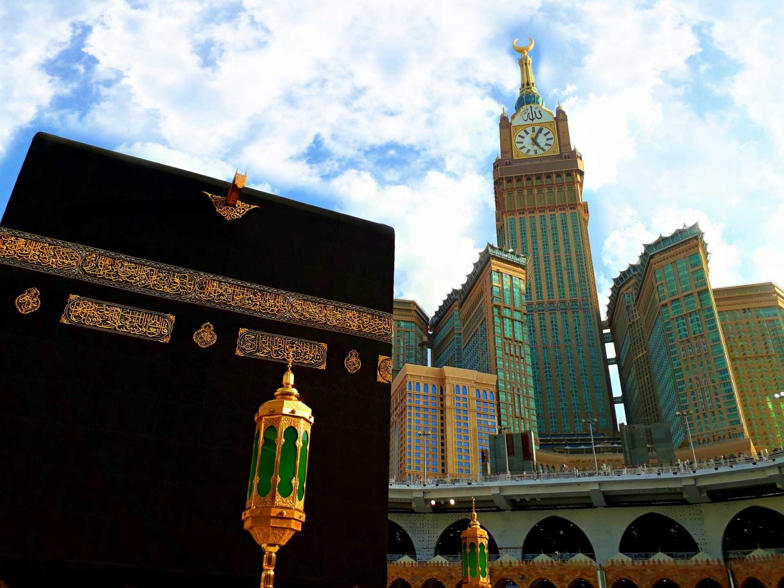 The Kaaba and the Makkah clock tower under a blue sky