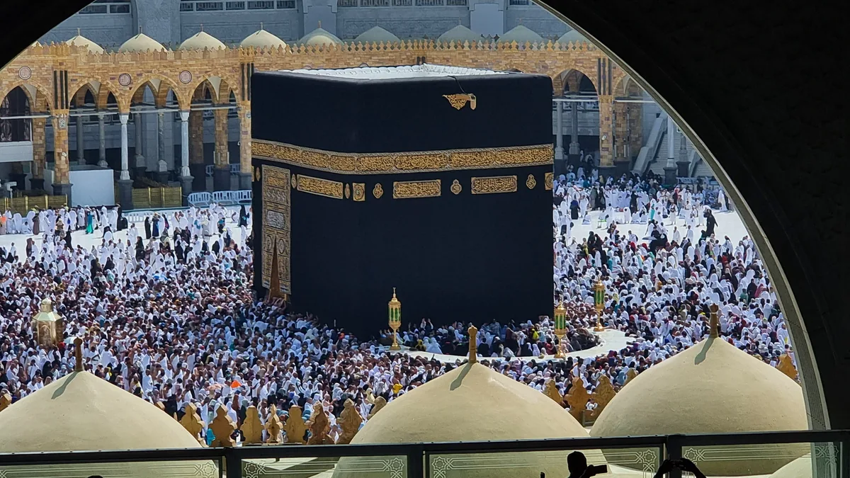 Worshippers on an upper floor looking out at the Kaaba